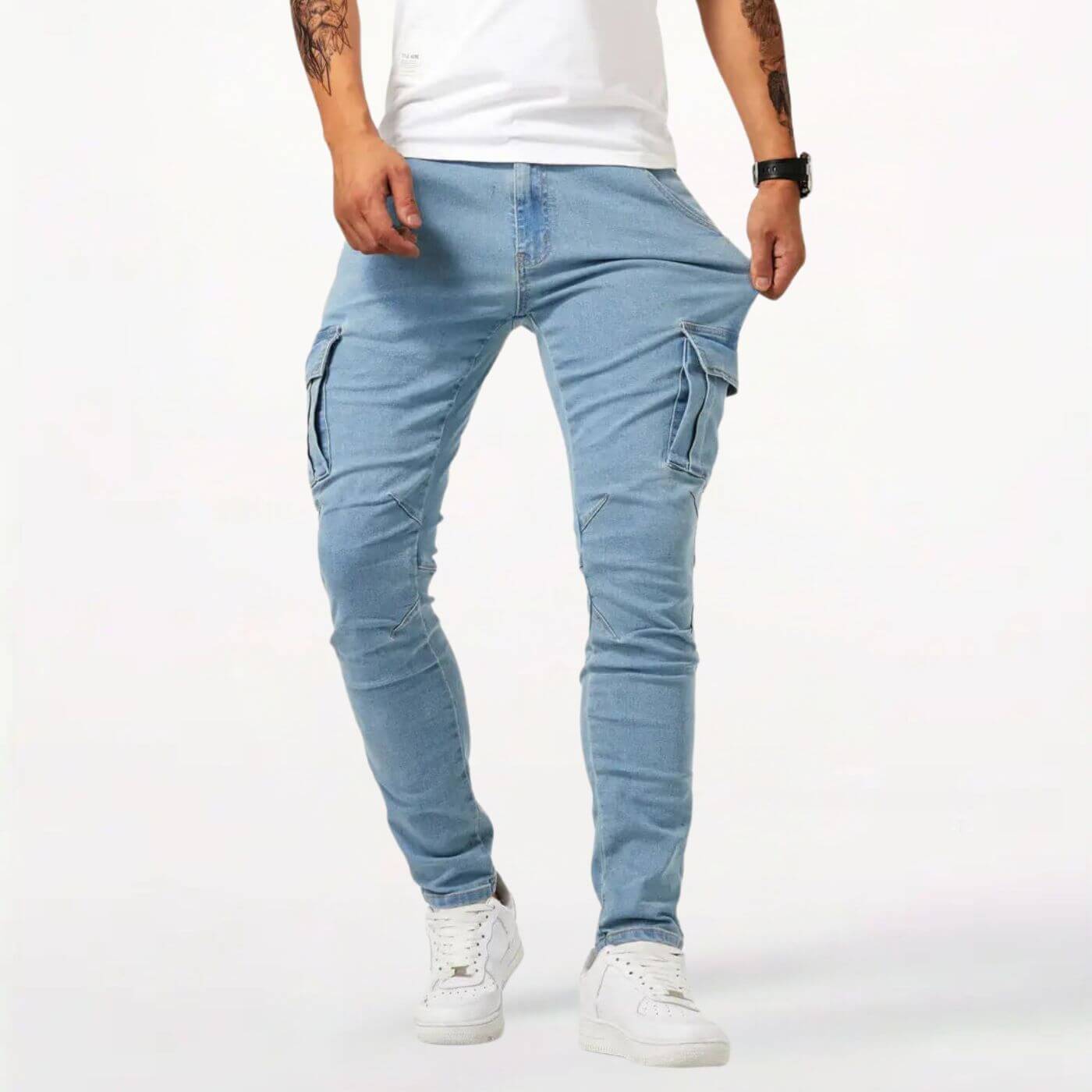 Pantalon cargo bleu clair ajusté pour homme avec poches utilitaires, stylé avec des baskets blanches.