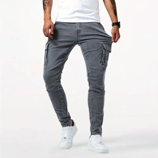 Pantalon cargo gris ajusté pour homme avec poches multiples, porté avec des baskets blanches.