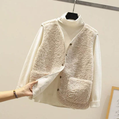 Gros plan d'un gilet en fausse fourrure beige sur un col roulé blanc, mettant en valeur la texture douce et les détails des boutons.